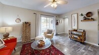 Located in Orlando, FL, this 2-bedroom, 2-bathroom single-floor residence offers a well-planned layout that balances open communal spaces with private retreats. The heart of the home is a combined living, dining, and kitchen area that flows seamlessly together. The living room features wood-look flooring, a ceiling fan, and large sliding glass doors that flood the space with natural light and open to a private balcony. The kitchen is outfitted with white shaker cabinetry, granite-style countertops, and stainless steel appliances, providing a clean and functional workspace. Both bathrooms are finished consistently with wood-look tile flooring, white vanities with granite-style countertops, and full tub-shower combinations with tiled surrounds. The primary bedroom is a generously sized retreat with plush carpeting, a ceiling fan, multiple windows, and direct access to a closet. The second bedroom also features carpet, a ceiling fan, and ample natural light. Three closets throughout the home provide abundant storage. Additional conveniences include a dedicated laundry area and a utility room. Neutral warm tones carry throughout, creating a cohesive and inviting ambiance across every room.