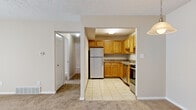 This single-floor unit in Brunswick, Ohio offers a practical and well-organized layout across a comfortable footprint. The combined living and dining area serves as the central gathering space, featuring neutral-toned carpet, a textured ceiling, and a sliding glass door that invites natural light and provides an outdoor view. A distinctive white brick accent wall adds character to the living area, while a pendant light fixture marks the dining space near the entry.

The kitchen is open to the main living area through an arched passthrough, creating a connected feel. It is outfitted with warm honey-toned wood cabinetry, dark granite-style countertops, light ceramic tile flooring, and stainless steel appliances including a refrigerator, range, and dishwasher.

Two carpeted bedrooms offer quiet retreats. The primary bedroom is generously sized and includes a spacious walk-in closet with built-in wire shelving for ample storage, as well as an additional closet. The second bedroom is cozy with easy hallway access.

The full bathroom features ceramic tile flooring, a wood vanity with granite-style countertop, a wall-mounted mirror, and a tub-shower combination. Hallways connect all rooms efficiently, completing this functional and cohesive layout.