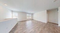 Located in Henderson, Nevada, this two-story home offers a well-organized layout across two floors. The ground level hosts an attached garage with an automatic opener, wall-mounted shelving, and direct interior access via a carpeted staircase leading up to the main living areas.

The upper floor encompasses the primary living spaces, including an open-concept living room, dining area, and kitchen. The kitchen features stainless steel appliances, modern cabinetry with frosted glass upper panels, and wood-look flooring that extends throughout the main living areas. The living room is bright and airy, benefiting from multiple windows that invite natural light.

Both bedrooms are carpeted and equipped with ceiling fans and windows with exterior views. The primary bedroom includes a walk-in closet outfitted with wire shelving systems. A dedicated laundry area with wire shelving provides added convenience.

The bathrooms are finished with clean, modern details. The primary bathroom features wood-look flooring, a long vanity with a light stone countertop, a backlit mirror, and a walk-in glass-enclosed shower. A second full bathroom serves the additional bedroom. Hallways connect all rooms efficiently, completing this functional and neatly designed home in the Sunridge Heights community.