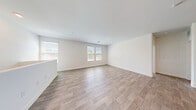 Located in Henderson, Nevada, this two-story home offers a well-organized layout across two floors. The ground level hosts an attached garage with an automatic opener, wall-mounted shelving, and direct interior access via a carpeted staircase leading up to the main living areas.

The upper floor encompasses the primary living spaces, including an open-concept living room, dining area, and kitchen. The kitchen features stainless steel appliances, modern cabinetry with frosted glass upper panels, and wood-look flooring that extends throughout the main living areas. The living room is bright and airy, benefiting from multiple windows that invite natural light.

Both bedrooms are carpeted and equipped with ceiling fans and windows with exterior views. The primary bedroom includes a walk-in closet outfitted with wire shelving systems. A dedicated laundry area with wire shelving provides added convenience.

The bathrooms are finished with clean, modern details. The primary bathroom features wood-look flooring, a long vanity with a light stone countertop, a backlit mirror, and a walk-in glass-enclosed shower. A second full bathroom serves the additional bedroom. Hallways connect all rooms efficiently, completing this functional and neatly designed home in the Sunridge Heights community.