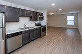 Located at 168 Bass Pro Dr in Sevierville, Tennessee, this single-floor unit offers a practical and well-appointed layout designed for comfortable everyday living. The open-concept design connects the kitchen directly to a spacious living area, creating a seamless flow throughout the main living space. Light wood-style flooring runs throughout the common areas, lending a clean and modern aesthetic.

The kitchen is fully equipped with a full suite of stainless steel appliances, including a refrigerator, electric range, over-the-range microwave, and dishwasher. Rich dark cabinetry provides ample storage and contrasts neatly with the light countertops and neutral wall tones. Recessed lighting illuminates the kitchen and main living areas effectively.

The bedrooms feature soft wall-to-wall carpeting and are brightened by windows with blinds that allow for natural light. The bathrooms are finished with dark vanity cabinetry, white countertops, and well-lit vanity mirrors, maintaining a consistent design palette throughout the unit. A dedicated laundry area with a stacked washer and dryer unit adds convenience. The overall ambiance is clean, neutral, and move-in ready, making it a functional and comfortable space in the heart of Sevierville.