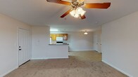 This single-story, 3-bedroom, 2-bathroom home offers a well-organized layout designed for comfortable everyday living. The open-concept living area serves as the heart of the home, featuring plush wall-to-wall carpeting and a ceiling fan with integrated lighting. A peninsula counter seamlessly connects the living space to the kitchen, creating a natural flow ideal for both daily routines and entertaining.

The kitchen is well-appointed with warm oak cabinetry extending to the upper walls for ample storage, granite-look laminate countertops, tile flooring, and a full suite of white appliances including a refrigerator, electric range, built-in microwave, and dishwasher. A galley-style layout maximizes efficiency within the space.

Each of the three bedrooms is carpeted and benefits from natural light through windows fitted with blinds. Ceiling fans are present in the bedrooms, contributing to year-round comfort. The rooms offer a neutral palette, providing a versatile backdrop for a variety of furnishing styles.

The two bathrooms are finished with tile flooring and clean, light-toned walls. Each bathroom is straightforward in design, featuring chrome hardware accents and towel bars. The overall aesthetic throughout the home is clean and neutral, making it a practical and move-in ready residence.