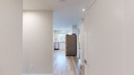This 2-bedroom, 2-bathroom single-floor unit offers a clean, contemporary design with a practical and efficient layout. The open kitchen and living area serves as the heart of the home, featuring light hardwood-style flooring, white shaker cabinetry, stainless steel appliances including a full-size refrigerator and dishwasher, and recessed lighting. A window above the sink brings in natural light, contributing to the bright and airy atmosphere of the space.

The primary bedroom is a comfortable, well-proportioned room with soft carpeting and a large window fitted with vertical blinds, offering views of surrounding greenery and the neighbourhood beyond. The second bedroom is equally functional, with the same neutral carpet and warm, neutral-toned walls. A dedicated closet provides additional storage.

Both bathrooms are finished with white cabinetry, a vanity with a light countertop, dark tile flooring, and a full bathtub with shower. The in-unit laundry room houses a stacked washer and dryer set on light hardwood-style flooring, adding a high level of everyday convenience. Throughout the unit, the consistent use of neutral tones, clean lines, and practical finishes creates a cohesive and inviting living environment.