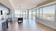 Located at 2827 Telek Pl in Alexandria, VA, this two-bedroom, two-bathroom residence offers a well-designed single-floor layout with a thoughtful blend of modern finishes and functional spaces. The open living area is a standout feature, boasting floor-to-ceiling windows and sliding glass doors that lead to a private balcony, flooding the space with natural light and offering sweeping views of the surrounding Alexandria landscape. Light wood-style flooring flows throughout the main living areas, enhancing the bright and airy atmosphere.

The kitchen is equipped with stainless steel appliances, including a refrigerator, range, microwave, and dishwasher. Rich, dark wood-tone cabinetry extends to the ceiling, complemented by white quartz countertops, a subway tile backsplash, and a central island ideal for additional prep space or casual dining.

The primary bedroom is a comfortable retreat with plush carpeting and access to an en-suite bathroom featuring a dual-sink vanity with wood-tone cabinetry, white countertops, a large mirror with modern lighting, and a walk-in closet outfitted with wire shelving and built-in organizers. The second bathroom offers a tiled tub-shower combination and matching contemporary cabinetry. The second bedroom features carpeted floors, a window with natural light, and a double-door reach-in closet.