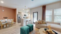 Located on Lakefront Drive in Sarasota, Florida, this single-floor residence showcases a thoughtfully curated interior that blends bold design choices with functional living. The entryway sets an immediate tone with eye-catching botanical-print wallpaper, warm wood-tone flooring, and a striking terracotta accent wall that carries through the main corridor, creating a cohesive visual thread throughout the home.

The open-concept living and dining area is bright and inviting, with multiple windows allowing natural light to fill the space. A glass-panel door provides additional light and outdoor access. The kitchen features white cabinetry with matte black hardware, stainless steel appliances, a subway tile backsplash, pendant lighting, a built-in wine rack, and a peninsula with bar seating—ideal for both cooking and entertaining.

Two bedrooms offer distinct personalities: the primary bedroom is serene and minimalist with light wood flooring and clean white walls, while the secondary bedroom features a soft blue patterned accent wall and natural light from window treatments. Both bathrooms are finished with large-format marble-look tile flooring, white cabinetry, white countertops, and matte black fixtures. A dedicated laundry room with a full-size washer and dryer adds everyday convenience.