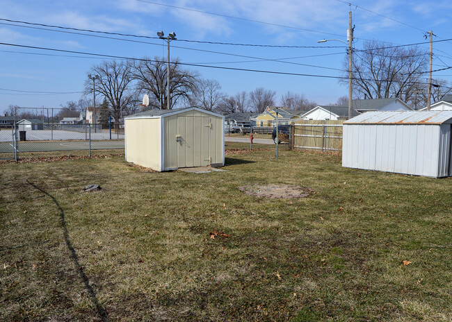 Fenced backyard with storage shed borders Dickson Park. - 224 4th St E