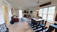 Located at 7306 Aberdeen in Lubbock, Texas, this single-story home offers a thoughtfully designed layout that balances comfort and functionality. The open-concept living and dining area forms the heart of the home, where carpet flooring, natural light from large windows, and a sliding glass door leading to the outdoors create a bright and welcoming atmosphere. A fireplace with a wood mantel anchors the living room, adding warmth and character. The dining area is illuminated by a pendant light and flows seamlessly into the kitchen via a pass-through window, which enhances the sense of openness. The kitchen features warm wood cabinetry, light countertops, black appliances, and hardwood-style flooring, with in-unit laundry conveniently located nearby. The bedrooms are carpeted and well-lit, each equipped with ceiling fans and windows that allow natural light to filter in. Crown molding adds a refined touch to the bedroom spaces. The primary bedroom connects directly to a spacious en-suite bathroom featuring dual sinks, warm wood vanity cabinetry, a large mirror, and a separate water closet. A second bathroom mirrors similar finishes, offering dual sinks and ample counter space. This home presents a comfortable and cohesive living environment throughout.
