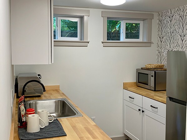 La cocina tiene refrigerador nuevo, lavavajillas nuevo, microondas, horno tostador y placa eléctrica. - 3334 SW Luradel St