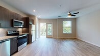 Located at 2190 Northlake Pkwy in Tucker, Georgia, this studio unit offers a well-designed, single-floor layout that maximizes functionality within a compact footprint. The open-concept living and kitchen area is finished with wood-style plank flooring, recessed lighting, and a ceiling fan, creating a bright and airy atmosphere. Large windows and a glass-panel balcony door flood the space with natural light and provide views of surrounding greenery, while the private balcony offers a pleasant outdoor retreat.

The kitchen is outfitted with dark espresso cabinetry, granite countertops, a textured tile backsplash, and a full suite of stainless steel appliances including a refrigerator, electric range, built-in microwave, and dishwasher. An in-unit washer and dryer are also included.

The bathroom features dark wood cabinetry paired with granite countertops, an undermount sink, a large vanity mirror, and wood-style tile flooring. A spacious walk-in closet with wire shelving and carpeted flooring provides ample storage. The unit's neutral color palette and modern finishes contribute to a clean, contemporary ambiance throughout.