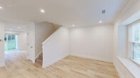 Located at 279 Lindenwood Drive in Exton, PA, this two-story, two-bedroom, two-bathroom home offers a thoughtfully designed layout spread across two floors. The main level provides a generous, open living area finished with light hardwood flooring, recessed lighting, and crisp white walls that create a bright, airy ambiance. A classic fireplace with a white mantel and black surround serves as a focal point in the living room, adding warmth and character. The kitchen is a standout feature, showcasing white shaker cabinets, a subway tile backsplash, marble-look quartz countertops with a peninsula, stainless steel appliances, and a window above the sink that invites natural light. Upstairs, the two bedrooms are carpeted for comfort, with the primary bedroom offering notable space, ample closet access, and windows with outdoor views. The two bathrooms are finished in a clean, neutral palette featuring marble-look tile flooring, white vanities with stone countertops, tiled shower surrounds, and brushed gold hardware accents. Outside, the property backs to an expansive, well-maintained lawn framed by mature trees, offering a serene and private outdoor retreat.