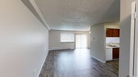 Located at 1917 22nd Way NE in Auburn, WA, this one-bedroom, one-bathroom unit offers a practical and well-organized single-floor layout. The combined kitchen and living room forms the heart of the space, featuring durable wood-look plank flooring throughout. The living area is bright and open, with a large window and sliding glass door that invite natural light and provide outdoor views. A ceiling fan with light fixture adds comfort and functionality, while baseboard heating units ensure warmth throughout the colder months. A textured ceiling adds a classic residential character to the space.

The kitchen is defined by its peninsula-style breakfast bar with a clean white countertop, offering both workspace and casual seating. Rich wood-toned upper cabinetry provides ample storage, complemented by a full set of appliances including a range and refrigerator.

The bedroom is a comfortable, carpeted retreat featuring neutral tones, a window with blinds, and a notable dual-closet configuration with bifold wood doors — providing generous storage for personal belongings. The bathroom is clean and functional, appointed with a vanity, mirror with wood frame, and a window with blinds for natural light. A hallway connects the main living spaces, completing this efficiently designed and move-in-ready home.