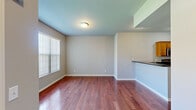 This three-story home offers a thoughtfully organized layout across three distinct floor levels, each progressively larger, maximizing the overall living space efficiently. The ground floor, the most compact of the three, houses an attached garage with an automatic opener, a painted concrete floor, and a utility room, providing practical storage and parking solutions.

The main living level features rich, warm-toned hardwood flooring throughout the open living and dining areas. A windowed kitchen with a peninsula counter finished in dark granite flows naturally into the living space, offering warm wood cabinetry, a stainless steel dishwasher, and a sink. Natural light filters through vertical-blind-covered windows, brightening the open floor plan.

The upper floor, the largest of the three levels, contains the three bedrooms and bathrooms. Bedrooms feature neutral gray carpet, light-toned walls, and white panel doors. The primary bedroom offers a comfortable, well-proportioned space. Bathrooms are finished consistently with dark granite vanity countertops, vessel-style sinks, large wall mirrors, and at least one tiled walk-in shower with a framed glass door. Two staircases connect the floors, ensuring smooth circulation throughout the home.