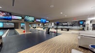 Located at 1000 Elements Way in Irvine, CA, this single-floor entertainment amenity space is a fully equipped recreational destination designed for social engagement and leisure. The layout is thoughtfully organized, with floor-to-ceiling glass partitions dividing distinct activity zones while maintaining an open, connected feel throughout.

The bowling area anchors one section of the space, featuring polished lanes framed by overhead flat-screen monitors and comfortable seating with teal upholstered chairs. Adjacent to the lanes, a dedicated billiards lounge offers a full-size pool table and built-in banquette seating, accented by dramatic large-scale wall murals depicting action sports and aviation imagery, adding a bold visual identity to each nook.

A gaming and lounge zone features curved pod-style gaming chairs, wall-mounted screens, and a full poker/game table surrounded by contemporary seating — ideal for group entertainment. A separate open-plan area with polished white flooring provides flexible gathering space with round café-style tables and wire chairs, plus a bar and kitchenette setup in the background.

Throughout the space, a wave-patterned carpet ties the zones together, complemented by recessed lighting, globe pendant fixtures, and modern décor. The overall ambiance is sleek, vibrant, and social — a sophisticated amenity space designed for an active community.