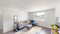 Located at 2343 Memorial Ave SW in Roanoke, Virginia, this single-floor, 2-bedroom, 1-bathroom home offers a clean, modern aesthetic with a light and airy feel throughout. The living room is a welcoming space, featuring neutral gray walls, hard-surface flooring, and a large window that fills the room with natural light and views of the surrounding greenery. A hallway connects the main living areas to the private quarters with ease. The dedicated dining room comfortably accommodates a full dining set and is brightened by its own window, creating a pleasant space for meals. The kitchen is thoughtfully appointed with crisp white cabinetry, light marble-style countertops, a stainless steel sink, dishwasher, and a full-size refrigerator. The spacious primary bedroom offers generous room for furnishings, while the second bedroom is cozy and well-lit with a window overlooking the exterior. Both rooms benefit from ample closet storage, with three closets distributed throughout the home. The full bathroom features a shower/tub combination, a window for natural ventilation, and a classic white vanity. Consistent hard-surface flooring runs throughout, tying the home together with a cohesive, contemporary style.
