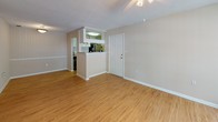 Located at 3339 Handy Rd in Tampa, Florida, this single-floor residence offers a well-organized layout with a consistent design throughout. The living area is open and inviting, featuring warm wood-look flooring, neutral-toned walls, and a textured ceiling with a ceiling fan. Natural light enters through windows fitted with blinds, and a sliding glass door provides access to the outdoors. The kitchen is designed in a galley style, lined with white cabinetry — including upper glass-front display cabinets — and light gray countertops. It is equipped with a stainless steel refrigerator, electric range, and a built-in sink, all set atop matching wood-look flooring. A half-wall peninsula connects the kitchen to the main living space, enhancing the open feel. The bedroom features plush carpeting and neutral walls, offering a quiet and comfortable retreat. The full bathroom is appointed with a tub-shower combination, a wide vanity with white cabinetry and a light stone-style countertop, a large mirror, and wood-look flooring. A dedicated in-unit laundry closet, concealed behind louvered bifold doors, houses a full-size washer and dryer with overhead shelving for added storage.