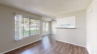 Located at 450 N Soldano Ave in Azusa, CA, this one-bedroom, two-bathroom unit offers a well-organized single-floor layout designed to maximize functionality. Rich, dark hardwood-style flooring runs throughout, providing a cohesive and polished look across all rooms.

The living and dining areas share an open, connected feel, with multiple large grid-pane windows that flood the space with natural light and offer pleasant views of lush greenery outside. A ceiling fan adds comfort to the living area, which also features a pass-through opening to the kitchen, enhancing the sense of openness.

The galley-style kitchen is well-appointed with white cabinetry, dark countertops, black appliances including an electric range, a dishwasher, and an overhead exhaust fan. A skylight-style ceiling panel adds brightness to the cooking space, and a window at the end of the kitchen lets in additional natural light.

The bedroom is a quiet, private retreat with a window and ample wall space. It connects to a dedicated closet with built-in shelving and hanging rods for organized storage. The two bathrooms include a vanity with white cabinetry and dark countertops. A separate pantry and a patio round out the layout, adding practical storage and outdoor access to this efficiently designed home.