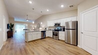 Located at 9422 Darrow Rd in Twinsburg, Ohio, this single-floor residence offers a thoughtfully designed layout with modern finishes and a warm, neutral palette throughout. The open-concept kitchen is a standout feature, showcasing crisp white shaker cabinetry, granite-style countertops, a peninsula with an undermount sink, and a full suite of stainless steel appliances including a refrigerator, range, microwave, and dishwasher. Pendant lighting and recessed fixtures illuminate the space, while vaulted ceilings in the kitchen area add a sense of height and openness. Light wood-look flooring flows seamlessly through the main living areas, complementing the airy, contemporary aesthetic. The living room offers a comfortable, neutral ambiance with soft lighting and easy access to an adjoining flex space or den, which features sliding glass doors that invite natural light and outdoor views. Bedrooms are carpeted for warmth and comfort, each equipped with ceiling fans and windows that provide natural light. The bathroom is well-appointed with white cabinetry, granite countertops, a large vanity mirror, and a tub-shower combination. Overall, the residence delivers a cohesive, move-in-ready environment with clean lines and functional, well-proportioned spaces throughout.