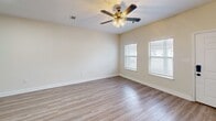 Located at 11350 New Orleans Ave in Gulfport, Mississippi, this single-floor residence offers a practical and comfortable layout with two bedrooms and two bathrooms. Light wood-look flooring runs consistently throughout the home, creating a cohesive and easy-to-maintain interior.

The kitchen is a standout feature, outfitted with distinctive sage green cabinetry, granite-style countertops, and a peninsula with an undermount sink — providing both ample prep space and a natural gathering point. White appliances, including an electric range with an over-the-range microwave, complete the functional setup. Bright recessed panel lighting keeps the kitchen well-illuminated.

The combined kitchen and living area forms the heart of the home, flowing naturally into the rest of the space. Both bedrooms are generously proportioned, each featuring ceiling fans with light kits and windows fitted with blinds that allow for natural light. The spacious primary bedroom includes access to a closet and an adjacent bathroom. Both bathrooms are identically appointed with full tub-shower combinations, chrome fixtures, and handheld showerheads.

A welcoming entryway with a paneled front door and a connecting hallway ties the layout together efficiently. The overall design is clean, neutral, and move-in ready.