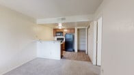 Located at 1970 W Valencia Rd in Tucson, Arizona, this efficiently designed one-bedroom, one-bathroom unit offers a well-organized layout across a single floor. The open-concept living area flows seamlessly into the kitchen, which features warm wood-toned cabinetry, marble-style laminate countertops, a double stainless steel sink, and black appliances including a refrigerator, range, and over-the-range microwave. A peninsula breakfast bar separates the kitchen from the carpeted living room, creating a practical and social divide between the two spaces. Wood-look vinyl flooring runs throughout the kitchen area, adding a clean, cohesive aesthetic. Adjacent to the kitchen is a dedicated open closet with built-in shelving, providing convenient storage. The bedroom is carpeted and bathed in natural light through a window dressed with vertical blinds, offering a calm and comfortable retreat. A textured ceiling is consistent throughout the unit. The bathroom includes a full tub-shower combo with white tile surround, a wood-vanity with a marble-style countertop, and wood-look flooring, creating a tidy and functional space. This unit offers a practical and comfortable living environment suited for those seeking simplicity and efficiency in Tucson.
