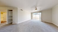 Located in Peoria, Arizona, this single-story 2-bedroom, 2-bathroom home offers a well-designed layout with a comfortable flow throughout. The open living room is bright and welcoming, featuring plush carpet, crown molding, a ceiling fan, and a sliding glass door that opens to a covered patio, flooding the space with natural light. The kitchen is outfitted with stainless steel appliances including a refrigerator, range, and microwave, complemented by light wood-toned cabinetry and a clean white countertop, with wood-look flooring that adds warmth and durability. Both bedrooms are carpeted and include ceiling fans; the secondary bedroom features a window with natural light, while the primary bedroom offers generous proportions and direct access to its en-suite bathroom. The primary bathroom showcases a modern floating-style vanity with wood-grain cabinetry, a white quartz countertop, brushed nickel fixtures, and stylish pendant lighting. The second bathroom includes a tub-shower combo with clean white finishes and wood-look tile flooring. A dedicated in-unit laundry room with a full-size washer and dryer adds everyday convenience. Each bedroom includes its own closet, completing this well-appointed home.