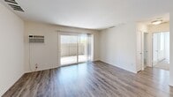 Located at 9090 Moody St in Cypress, CA, this single-story 2-bedroom, 2-bathroom unit offers a practical and well-appointed layout. The living room serves as the central gathering space, featuring wood-style laminate flooring, a wall-mounted air conditioning unit, and a sliding glass door that opens to a private outdoor patio, bringing in natural light and outdoor access.

The galley-style kitchen is efficiently designed with white shaker cabinetry, granite-style countertops, a gas range, a dishwasher, a stainless steel sink, and recessed lighting overhead. Both bedrooms are carpeted and equipped with ceiling fans. The primary bedroom includes a spacious closet, while the second bedroom features a closet and a window with natural light.

The bathrooms are finished with wood-style flooring, white cabinetry, and granite-style countertops. One bathroom includes a full tub-shower combination, while the primary bath features an extended vanity with a large mirror and overhead lighting. Throughout the unit, a neutral color palette and consistent finishes contribute to a clean, cohesive aesthetic.
