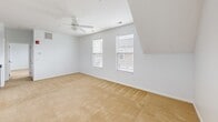 Located at 1421 1/2 Chambers Road in Columbus, Ohio, this one-bedroom, one-bathroom home offers a well-designed layout across a single floor. The space features notable architectural character, with vaulted and angled ceilings that add visual interest and a sense of openness throughout the bedroom and living areas. Soft carpeting runs through the bedroom and living spaces, while wood-look flooring anchors the kitchen area.

The combined kitchen and living room serves as the heart of the home. The kitchen is equipped with dark espresso cabinetry, granite-style countertops, and a full suite of stainless steel appliances including a refrigerator, electric range, over-the-range microwave, and dishwasher. A peninsula with a double sink and pendant lighting above creates a natural divide between the kitchen and living area, which benefits from multiple windows that allow abundant natural light to fill the space.

The bedroom is generously sized, featuring a ceiling fan, angled ceilings, and multiple windows with views of the surrounding neighborhood. It connects to a walk-in closet outfitted with wire shelving and storage racks. The bathroom includes a granite-top vanity and a full tub-shower combination with a curved curtain rod. The home also includes a dedicated entrance, completing its functional and comfortable layout.