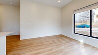 This 700 square foot apartment maximizes space efficiency with its thoughtful layout. The home features three bedrooms, including a primary bedroom of 130 square feet, and two full bathrooms. The open-concept design seamlessly integrates the kitchen with the living area, creating a sense of spaciousness.

The kitchen boasts white cabinetry, stainless steel appliances, and a subway tile backsplash, complemented by light wood-look flooring. A central island provides additional counter space and delineates the cooking area from the rest of the living space. Pendant lighting adds a modern touch to the kitchen's aesthetic.

Bedrooms are carpeted for comfort and feature large windows that allow natural light to flood the spaces. The bathrooms are equipped with modern fixtures, including a bathtub-shower combination in at least one, and continue the home's clean, white color scheme.

Throughout the apartment, neutral-toned walls and ample windows create a bright, airy atmosphere. The use of consistent flooring – wood-look in common areas and carpet in bedrooms – unifies the space. Black window frames provide a striking contrast to the light interior, adding a contemporary edge to the overall design.