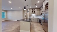 This contemporary single-story residence offers a well-designed living space of 1290 square feet. The home features two bedrooms, including a spacious primary bedroom of 280 square feet, and three bathrooms for added convenience. The open-concept layout seamlessly integrates the kitchen and living room, creating an inviting atmosphere for both relaxation and entertaining.

The interior boasts modern finishes, as evidenced by the sleek recessed lighting and neutral-toned walls. Large windows flood the space with natural light, while providing views of the surrounding area. The flooring throughout is a durable and attractive wood-look material, adding warmth and easy maintenance to the home.

The room shown in the image, likely the living area, showcases the property's attention to detail. It features a spacious layout with ample room for furniture arrangement. The space is further enhanced by a glass door, possibly leading to an outdoor area, which adds to the overall sense of openness and connection to the exterior.

With two closets, the home offers practical storage solutions. The combination of modern amenities, thoughtful design, and generous proportions makes this property an appealing option for those seeking a contemporary living space.