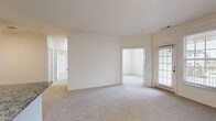 This contemporary 800 square foot apartment offers a well-designed living space with two bedrooms and one bathroom. The heart of the home is the updated kitchen, showcasing sleek granite countertops, dark wood cabinetry, and stainless steel appliances including a microwave, refrigerator, and gas range. The kitchen's L-shaped layout maximizes efficiency and provides ample counter space for meal preparation.

The bathroom features a modern design with a white bathtub, curved shower rod, and neutral tile flooring. Both bedrooms are carpeted and benefit from large windows that flood the spaces with natural light, while also offering views of the surrounding area. Window treatments include horizontal blinds for privacy control.

Throughout the apartment, you'll find neutral-toned walls and carpeting in the living areas and bedrooms, creating a bright and airy atmosphere. The property boasts high ceilings and recessed lighting, adding to the overall sense of spaciousness. A notable feature is the open floor plan, which allows for a seamless flow between living spaces. The apartment's layout, as seen in the floor plan image, demonstrates an efficient use of space, making it ideal for comfortable modern living.