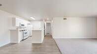 Located in the Northridge neighborhood of Los Angeles, this single-floor residence offers a well-designed 2-bedroom, 2-bathroom layout. The open-concept kitchen and living area serves as the heart of the home, featuring light wood-look flooring that flows seamlessly throughout. The kitchen is bright and functional, highlighted by a skylight that floods the space with natural light, white cabinetry with stone-look countertops, a center island with a sink, and white appliances including a gas range. A secondary peninsula provides additional counter space, making this an efficient and practical kitchen. The living area transitions naturally from the kitchen, offering a comfortable, versatile space with neutral tones and clean lines. Both bedrooms are carpeted and generously sized, with the primary bedroom offering a spacious footprint, a large window with outdoor views, and ample room to customize. The second bedroom is equally comfortable with soft carpeting and neutral walls. Both bathrooms are finished with white cabinetry, stone-look countertops, full tub-shower combinations, and light wood-look flooring, maintaining the cohesive, clean aesthetic found throughout. The entire residence is presented in a bright, neutral palette that enhances the sense of openness and light.