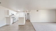 Located in the Northridge neighborhood of Los Angeles, this single-floor residence offers a well-designed 2-bedroom, 2-bathroom layout. The open-concept kitchen and living area serves as the heart of the home, featuring light wood-look flooring that flows seamlessly throughout. The kitchen is bright and functional, highlighted by a skylight that floods the space with natural light, white cabinetry with stone-look countertops, a center island with a sink, and white appliances including a gas range. A secondary peninsula provides additional counter space, making this an efficient and practical kitchen. The living area transitions naturally from the kitchen, offering a comfortable, versatile space with neutral tones and clean lines. Both bedrooms are carpeted and generously sized, with the primary bedroom offering a spacious footprint, a large window with outdoor views, and ample room to customize. The second bedroom is equally comfortable with soft carpeting and neutral walls. Both bathrooms are finished with white cabinetry, stone-look countertops, full tub-shower combinations, and light wood-look flooring, maintaining the cohesive, clean aesthetic found throughout. The entire residence is presented in a bright, neutral palette that enhances the sense of openness and light.