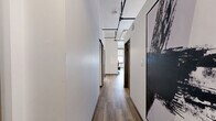 Located on the sixth floor of 305 Michigan Ave in downtown Detroit, this one-bedroom, one-bathroom unit offers a well-designed layout across a single floor. Wood-style flooring flows throughout, complemented by crisp white walls and an industrial-modern aesthetic highlighted by exposed ductwork and track lighting on the ceilings.

The combined living, dining, and kitchen area forms the heart of the unit. The living space features generous wall height and a large window offering views of the surrounding Detroit skyline. The kitchen is outfitted with white cabinetry with gold-tone hardware, stainless steel appliances including a refrigerator, range, and built-in microwave, as well as light quartz countertops and a utility sink. Track lighting illuminates the kitchen efficiently.

A hallway connects the main living area to the private spaces, lined with two closets offering ample storage. The bedroom is a calm, well-proportioned retreat with high ceilings, a sliding double-door closet, and wall-mounted lighting. The bathroom is clean and functional with wood-look tile flooring. The unit's overall design blends contemporary urban style with practical, livable finishes throughout.