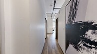 Located on the sixth floor of 305 Michigan Ave in downtown Detroit, this one-bedroom, one-bathroom unit offers a well-designed layout across a single floor. Wood-style flooring flows throughout, complemented by crisp white walls and an industrial-modern aesthetic highlighted by exposed ductwork and track lighting on the ceilings.

The combined living, dining, and kitchen area forms the heart of the unit. The living space features generous wall height and a large window offering views of the surrounding Detroit skyline. The kitchen is outfitted with white cabinetry with gold-tone hardware, stainless steel appliances including a refrigerator, range, and built-in microwave, as well as light quartz countertops and a utility sink. Track lighting illuminates the kitchen efficiently.

A hallway connects the main living area to the private spaces, lined with two closets offering ample storage. The bedroom is a calm, well-proportioned retreat with high ceilings, a sliding double-door closet, and wall-mounted lighting. The bathroom is clean and functional with wood-look tile flooring. The unit's overall design blends contemporary urban style with practical, livable finishes throughout.