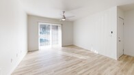 Located at 1025 W Main St in Hillsboro, Oregon, this one-bedroom, one-bathroom unit offers a thoughtfully designed single-floor layout that maximizes its cozy footprint. The open-concept kitchen and living area serves as the heart of the home, featuring light wood-style flooring throughout, crisp white walls, and recessed lighting. The kitchen is well-appointed with white shaker-style cabinetry, light countertops, a peninsula island, stainless steel appliances including a dishwasher and range hood, and a dedicated pantry for additional storage. The living area is bathed in natural light from a large sliding glass door fitted with vertical blinds, and is completed by a ceiling fan overhead. The bedroom offers a comfortable, carpeted retreat with a spacious double sliding-door closet, a window with natural light, and a baseboard heater. The full bathroom features wood-style tile flooring, a white vanity with ample cabinet storage, and a tub-shower combination. Together, these elements create a clean, functional, and inviting living space well-suited for everyday comfort in the heart of Hillsboro.