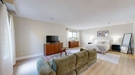 Located at 1001 Bridgeport Avenue in Shelton, Connecticut, this single-floor residence offers a thoughtfully arranged layout with one bedroom, three bathrooms, and three closets. The generously sized bedroom features light wood flooring, neutral toned walls, and multiple windows that invite abundant natural light. The open layout of the bedroom area accommodates both a sleeping space and a sitting area, providing functional versatility within a single room.

The kitchen is well-appointed with white cabinetry, granite-style countertops, stainless steel appliances including a refrigerator, dishwasher, and range, as well as a built-in microwave. Stone tile flooring grounds the kitchen space, which also features a peninsula counter with seating — ideal for casual dining or workspace use.

The bathrooms offer clean, practical finishes, with one featuring a long granite-topped vanity, warm wood cabinetry, and large-format tile flooring, providing ample counter and storage space.

Throughout the residence, the neutral color palette, light wood floors, and consistent design choices create a cohesive and calm ambiance. Three closets add notable storage capacity. This residence combines comfort and functionality in a well-maintained single-level layout in Shelton, CT.