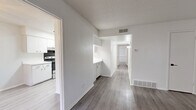Located at 1600 Jones Dr in Arlington, TX, this single-floor, 3-bedroom, 2-bathroom unit offers a clean and functional layout with modern finishes throughout. The entryway opens into a spacious living area featuring light gray luxury vinyl plank flooring, crisp white walls, and a textured ceiling. A seamless opening connects the living space to an additional room, both finished with matching flooring for a cohesive feel. The kitchen is equipped with white cabinetry, light countertops, a stainless steel sink, and a black electric range, all accented by light LVP flooring and recessed overhead lighting. Each of the three bedrooms is well-proportioned, with the generously sized primary bedroom offering ample room for full furnishings. The bedrooms feature ceiling fans with light fixtures, windows with blinds for natural light and privacy, and sliding closet doors for convenient storage. Both bathrooms are finished in a clean, white aesthetic — one featuring a subway-tiled tub/shower combo with a grab bar, and the other with an enclosed tub/shower unit, white vanity, and overhead cabinet. The overall ambiance is bright, neutral, and move-in ready.