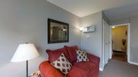 Located at 59 Fitzhenry Blvd in Columbus, Ohio, this two-floor property offers a well-organized and functional layout designed for comfortable everyday living. The interior features neutral gray walls throughout, providing a clean and versatile backdrop that complements a variety of décor styles. Carpeted flooring adds warmth and comfort underfoot across the living areas.

The main living area is cozy and inviting, highlighted by a plush seating arrangement and an ornately framed wall mirror that adds a touch of character to the space. A ceiling fan with integrated lighting provides both comfort and illumination, while wall-mounted fixtures and floor lamps offer additional lighting options. A wall-mounted thermostat and audio unit are conveniently positioned for easy access.

The open flow between the living and dining areas makes the space feel connected and practical. The dining area accommodates a table with seating for multiple guests and features a wall-mounted flat-screen television, adding a versatile, entertainment-ready element to the space. White-trimmed doorways lead to additional rooms, contributing to a bright and clean aesthetic throughout. Spanning two floors, this property provides ample room for both living and private spaces, making it a well-rounded home in a Columbus neighborhood.