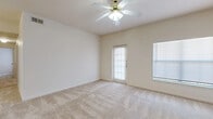 This single-story, 4-bedroom, 2-bathroom home offers a practical and comfortable layout designed for everyday living. The living room is bright and airy, featuring plush neutral carpeting, a ceiling fan with light fixture, and access to the outdoors through a glass-paneled door, allowing natural light to flow throughout the space. An additional window further enhances the open, welcoming ambiance.

The galley-style kitchen is efficiently designed with light wood cabinetry, dark countertops, wood-look flooring, and white appliances including a range, microwave, and dishwasher. It opens to a combined dining area, making it well-suited for both everyday meals and entertaining.

The four bedrooms are carpeted and feature neutral tones, with several rooms equipped with ceiling fans for added comfort. The primary bedroom offers a generous footprint with ample space for furnishings. The additional bedrooms are well-sized, each with natural light from windows.

Both bathrooms include light wood vanity cabinetry, dark countertops, and warm wood-look flooring, giving them a clean, cohesive look. Two hallways connect the rooms efficiently throughout the home. The overall design is clean and neutral, providing a versatile canvas for personalization.