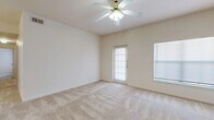 This single-story, 4-bedroom, 2-bathroom home offers a practical and comfortable layout designed for everyday living. The living room is bright and airy, featuring plush neutral carpeting, a ceiling fan with light fixture, and access to the outdoors through a glass-paneled door, allowing natural light to flow throughout the space. An additional window further enhances the open, welcoming ambiance.

The galley-style kitchen is efficiently designed with light wood cabinetry, dark countertops, wood-look flooring, and white appliances including a range, microwave, and dishwasher. It opens to a combined dining area, making it well-suited for both everyday meals and entertaining.

The four bedrooms are carpeted and feature neutral tones, with several rooms equipped with ceiling fans for added comfort. The primary bedroom offers a generous footprint with ample space for furnishings. The additional bedrooms are well-sized, each with natural light from windows.

Both bathrooms include light wood vanity cabinetry, dark countertops, and warm wood-look flooring, giving them a clean, cohesive look. Two hallways connect the rooms efficiently throughout the home. The overall design is clean and neutral, providing a versatile canvas for personalization.