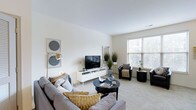 Located in Columbus, Ohio's 43206 zip code, this two-story residence at 345 East Deshler Avenue combines modern design with comfortable, functional living. The living area serves as the heart of the home, featuring neutral-toned walls and plush carpeting that create a warm, welcoming atmosphere. Large windows allow abundant natural light to fill the room, enhancing the open and airy feel of the space. The layout accommodates generous seating arrangements and a dedicated media area, making it well-suited for both relaxing and entertaining. The clean lines and understated color palette throughout the living space reflect a contemporary design sensibility, with subtle decorative touches that add character without overwhelming the room. Spreading across two floors, the residence offers a functional separation of living and private spaces, providing both openness on the main level and a sense of retreat on the upper floor. The overall ambiance of the home is calm and cohesive, with consistent finishes and a neutral design language that offers a versatile backdrop for a variety of interior styles. Its location in Columbus adds convenient access to the surrounding neighborhood's amenities.