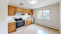 Located at 90 Charlesbank Way in Waltham, MA, this single-floor, 3-bedroom, 1-bathroom home offers a clean, bright, and functional layout. Light hardwood flooring runs throughout the main living and bedroom areas, creating a warm and cohesive aesthetic against the crisp white walls.

The spacious primary bedroom is notably generous in size, featuring multiple windows that invite natural light and offer views of surrounding greenery, along with a built-in closet with sliding doors. The two additional bedrooms are well-proportioned, each with hardwood floors and access to natural light.

The kitchen is well-equipped with warm oak cabinetry, stainless steel appliances including a range, dishwasher, and refrigerator, complemented by light countertops and a window overlooking the outdoors. The tile flooring in the kitchen adds a practical contrast to the rest of the home.

The bathroom features classic white tile work surrounding a tub-shower combination, with a window providing ventilation and natural light. Baseboard heating is present throughout the home, ensuring comfortable warmth year-round. A connecting hallway ties all rooms together in a practical, easy-to-navigate floor plan.
