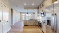 This 680 square foot apartment offers a well-designed living space on a single floor. The layout features one bedroom measuring 170 square feet, complemented by two bathrooms for added convenience. The heart of the home is an open-concept area combining the kitchen and living room, promoting a sense of spaciousness and flow.

The interior showcases modern finishes, as evident in the image provided. The living area boasts warm-toned laminate flooring, creating a cozy yet contemporary ambiance. Crisp white walls and baseboards contrast nicely with the flooring, enhancing the room's brightness. Recessed lighting in the ceiling provides even illumination throughout the space.

Large windows, including a sliding glass door, allow abundant natural light to flood the interior, making the room feel more expansive. These windows, adorned with white blinds, offer control over privacy and light. The glass door likely leads to an outdoor area, extending the living space and providing a connection to the exterior.

The room's clean lines and neutral color palette create a versatile canvas for various decorating styles. Despite its compact size, the apartment's thoughtful design ensures functionality and comfort, making efficient use of the available square footage.
