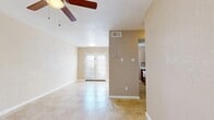 This single-floor space offers a practical and comfortable layout designed for easy living. The main living area is bright and open, finished with large neutral-toned tile flooring that flows throughout the unit. A ceiling fan overhead provides year-round comfort, while a set of classic French doors at the far end of the living room floods the space with natural light and offers an inviting sense of openness. A textured ceiling adds subtle architectural character throughout.

The kitchen is efficiently designed with warm wood cabinetry, a tile backsplash, and black appliances including an electric range and refrigerator. A wraparound breakfast bar countertop connects the kitchen to the living and dining area, creating a seamless, open-concept feel ideal for both cooking and casual interaction.

The bedroom is a well-proportioned retreat featuring its own ceiling fan, large tile flooring, and a window with blinds that lets in natural light. Two side-by-side closets provide generous storage and organizational flexibility.

The bathroom is clean and functional, featuring a walk-in shower with grab bars, a dark wood vanity with a light stone countertop, and matching tile flooring that ties the space together with a cohesive, neutral aesthetic. Overall, the unit presents a tidy, move-in-ready environment with consistent finishes throughout.