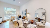 Located at 3050 Del Hombre Lane in Walnut Creek, CA, this well-appointed one-bedroom, one-bathroom residence offers a thoughtfully designed open-concept layout with modern finishes throughout. Light wood-style flooring flows through the main living areas, complemented by tall ceilings that enhance the sense of openness.

The kitchen is a standout feature, showcasing rich dark wood cabinetry extending to the ceiling, white quartz countertops, a tile backsplash, and a full suite of stainless steel appliances, including a refrigerator with water dispenser, range, and built-in microwave. A peninsula provides additional prep space and a natural transition into the living area.

The living room is bright and inviting, anchored by a large window framing lush tree canopy views, allowing generous natural light to fill the space throughout the day.

The bedroom is a calm retreat with soft carpet, a ceiling fan, and its own window overlooking greenery. It connects seamlessly to a dedicated walk-in closet equipped with built-in shelving and hanging rods.

The bathroom features a floating dark wood vanity, a large mirror with modern lighting, tile flooring, and a marble-accented walk-in shower, combining style with functionality in a clean, neutral palette.