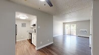 Located at 11501 Washington St in Northglenn, Colorado, this single-floor residence offers a thoughtfully updated interior with a clean, neutral aesthetic throughout. The open living area is bright and welcoming, featuring durable hardwood-style flooring, a ceiling fan, and baseboard heating. Large sliding glass doors lead to a private balcony, filling the space with natural light and providing pleasant views of the surrounding greenery. A wall-mounted air conditioning unit ensures year-round comfort.

The kitchen is well-appointed with crisp white shaker cabinetry, white subway tile backsplash, light quartz-style countertops, and black appliances including an electric range, refrigerator, and dishwasher — offering both style and functionality in a compact, efficient layout.

The bedrooms are carpeted for comfort and each features a closet with sliding or hinged doors, providing ample storage. The textured ceilings are consistent throughout the home, adding a classic residential character. The floorplan, visible in the 3D dollhouse view, reveals a well-organized layout with clear separation between the living, kitchen, and sleeping areas, making efficient use of the available space. This residence combines practical updates with a comfortable, move-in-ready feel.