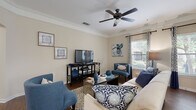 This single-floor residence offers a thoughtfully designed layout that balances comfort and functionality. The open-concept kitchen is equipped with dark espresso cabinetry, granite countertops, a tile backsplash, a stainless steel sink, and black appliances. A peninsula with pendant lighting connects the kitchen seamlessly to the dining area, which features a charming bay window that floods the space with natural light and offers pleasant outdoor views — an ideal setting for everyday meals.

The living room is generously proportioned, featuring crown molding, a ceiling fan, and hardwood-style flooring. Large windows dressed with patterned curtains bring in ample natural light and create an inviting, airy ambiance.

The primary bedroom is a serene retreat with plush carpeting, a ceiling fan, crown molding, and a large window with outdoor views. It is complemented by a spacious walk-in closet outfitted with dual wire shelving systems on both sides, offering extensive storage. A second bedroom is equally comfortable, also featuring carpet flooring and a ceiling fan.

The bathroom is well-appointed with a granite-topped dark vanity, wood-style flooring, a tub/shower combination, and recessed lighting. Warm, neutral tones carry throughout the entire residence, lending a cohesive and welcoming character to every room.
