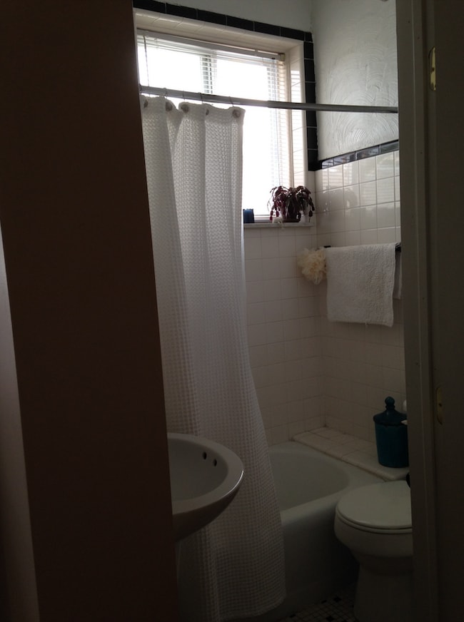 Baño con bañera y respaldo y azulejos de cerámica blanca. - 1243 S 22nd St