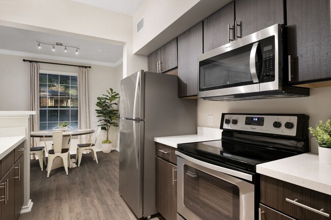 Apartments with wood style flooring and espresso cabinetry - The Lodge at Lakeline Village