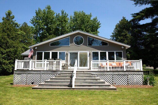 Frente de la casa con amplio deck, parrilla, mesa y sofá exterior. - 6 Sandy Cv