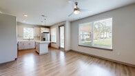 Located at Tomoka Town Center in Daytona Beach, FL, this single-story residence offers 2 bedrooms and 3 bathrooms thoughtfully arranged within a comfortable, functional floor plan. Light wood-tone flooring flows consistently throughout the home, complemented by neutral walls and a textured ceiling that lend a clean, contemporary aesthetic.

The open-concept living and kitchen area forms the heart of the home. The kitchen is outfitted with white shaker-style cabinetry, stainless steel appliances including a French door refrigerator with ice dispenser, a slide-in range, and a built-in microwave. A central island with a white countertop provides additional prep space and casual seating, while pendant lighting adds a modern accent. Large windows flood the combined living and kitchen area with natural light and offer views of the surrounding greenery, enhanced by ceiling fans in both the living area and bedrooms.

The spacious primary bedroom features direct access to its own bathroom and includes a dedicated closet outfitted with wire shelving for organized storage. The second bedroom is bright and well-sized, with a ceiling fan and a large window overlooking outdoor greenery. Bathrooms are finished with large-format tile surrounds. A dedicated in-unit laundry room houses a full-size washer and dryer. Two hallways connect the space efficiently, completing this well-designed residence.